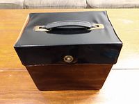 Black vintage travel storage box for 45 RPM records with carrying handle and lock clasp.