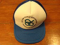 Hat laid flat on wooden surface, displaying entire front and brim showing logo and text.