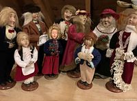 Photo showing 9 Christmas caroler figurines in various holiday attire and poses.