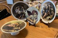 Plate group with Victorian portraits and cherub art on display stands