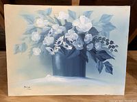 Painting with white flowers in a dark blue vase, soft blue leaves on muted light background