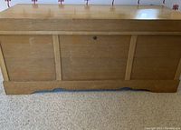 Front view of rectangular wooden Lane cedar chest showing panel details and lock on lid.