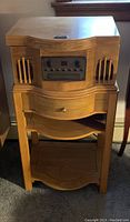 Front view of PHILCO wooden cabinet record player showing overall design and storage drawer below.