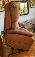 Side view of brown power lift recliner chair showing plush cushions and metal base.