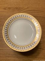 Top view of a single San Marco dinner plate showing the decorative gold and gray patterned border.
