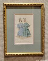 Front view of framed antique handcoloured fashion plate showing two women in 1830s dresses.