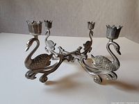 Side view of the silver plated ornate swan candelabra showing two swan figures and candle holders.