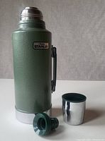 Full thermos with lid off, showing cup and stopper laid out