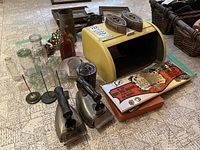 Wide view showing vintage electric irons, yellow metal breadbox, vintage glass bottles, and other accessories