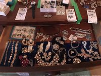 Tray of assorted costume jewelry including bracelets, necklaces, brooches and earrings arranged on blue velvet pads