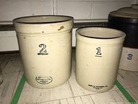Photo showing both 2 gallon and 1 gallon Imperial crocks side by side, showcasing size difference and labeling.