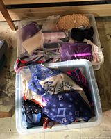 Two plastic totes filled with women's scarves, gloves, and handbags, arranged to show variety and condition.