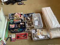 Overview of sewing supplies including organized boxes of threads, buttons, hooks and eyes, eyelets, scissors, and two fabric bolts