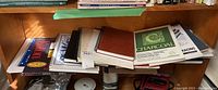 Shelf with collection of sketchbooks and drawing paper pads, including a charcoal pastel pad and various spiral bound sketchbooks