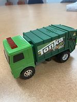 Photos of 2008 Tonka green recycle truck showing side and angle view, illustrating green body, red lights on cab roof, Tonka logo on side and silver wheels.