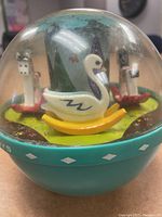 1966 turquoise Roly Poly Chime Ball with clear dome showing swan and hanging flower musical elements