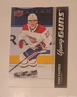 Front side of the hockey trading card showing Cole Caufield in action wearing Montreal Canadiens jersey, with 'Young Guns' on the right side and Upper Deck logo top left.