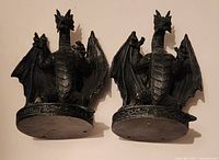 Front view of two black dragon bookends side by side, showing detailed scales, wings, and facial features.