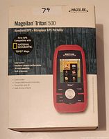 Front of original box showing device image and features including color screen, electronic compass and barometer, SD-card compatibility, built-in basemap, and compatibility with National Geographic and TOPO maps.