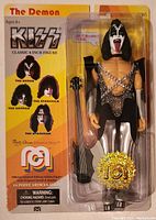 Front view of the sealed Kiss The Demon 8-inch figure showing the figure inside packaging with guitar and limited edition seal.