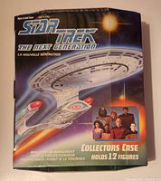 Box front showing Star Trek The Next Generation branding, USS Enterprise image, and text indicating it holds 12 figures, with main cast art on bottom right