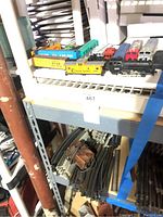 HO scale train set including engines, cabooses, and track on a basement shelf.