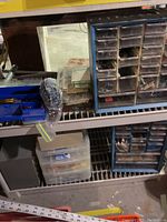 Wide shot showing two large plastic parts cabinets and a clear three-drawer container on lower shelf, along with other small containers and hardware boxes.