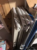 Photo of one disassembled plastic shelving unit with shelves and poles laid on top.