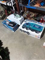 Photo showing the lot including the Mercedes-Benz 1850L truck kit box, helicopter, boat, and radio controller arranged on the floor.