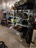 White metal shelving unit with four shelves. Various items stored but not included in sale.