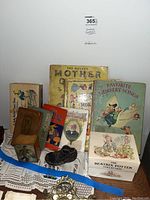 Photo of collection of vintage children's books and related items on doily-covered surface