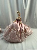 Front view of the Barbie doll in pink satin gown with lace and sequins, showing full length and hairstyle.