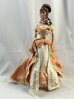 Full front view of the Barbie Orange Pekoe Doll wearing peach and ivory gown.