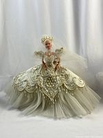 Front view of Barbie doll in ivory gown with gold embroidery