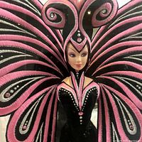 Close-up photo showing Barbie doll's head, pink hair, detailed embroidery, rhinestones on black velvet gown, and butterfly wings with pink and silvery embroidery.