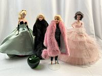 Four dolls together with green apple prop