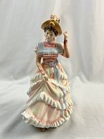 Front view of the Royal Doulton 'Sharon' figurine showing detailed pastel dress and posed hand near hat.