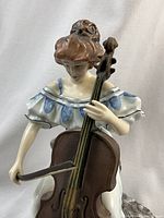 Front close-up of figurine showing cellist details