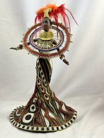 Full front view of doll on stand showing gown, collar and headdress