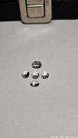 Five oval cut natural crystal quartz gemstones arranged, showing clear transparency and faceting under light.
