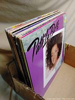 Photo showing side view of multiple vinyl record albums stacked vertically in a cardboard box, with Patti LaBelle album at front.