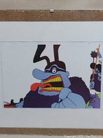 Front view of the Blue Meanie animation cel with backing board showing main character and background details.