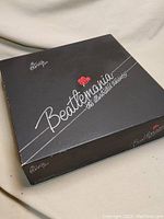 Black Beatlemania game box with white and red lettering and rose logo