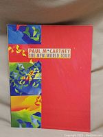 Full cover of the 1990 Paul McCartney The New World Tour program booklet with colorful abstract design.