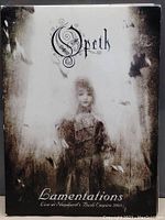 Front cover of the Opeth Lamentations live DVD showing a gothic-style portrait of a woman in sepia tones.