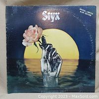 Front album cover showing the artwork with metallic hand holding a rose and large yellow sun.