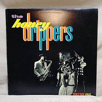 Front cover of The Honeydrippers Volume One vinyl record album showing band members playing instruments with colorful title text.