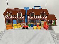 Front view of Little People Fisher Price Cottage playset with furniture and figures arranged in front