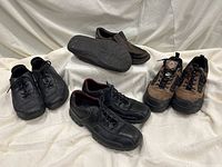 Photo of four pairs of men's shoes including black lace-ups, brown slip-ons, and Workload work shoes.