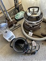 Photo showing the Filter Queen vacuum cleaner, blender, electric fondue pot, and Eureka Enviro vacuum cleaner in the background.